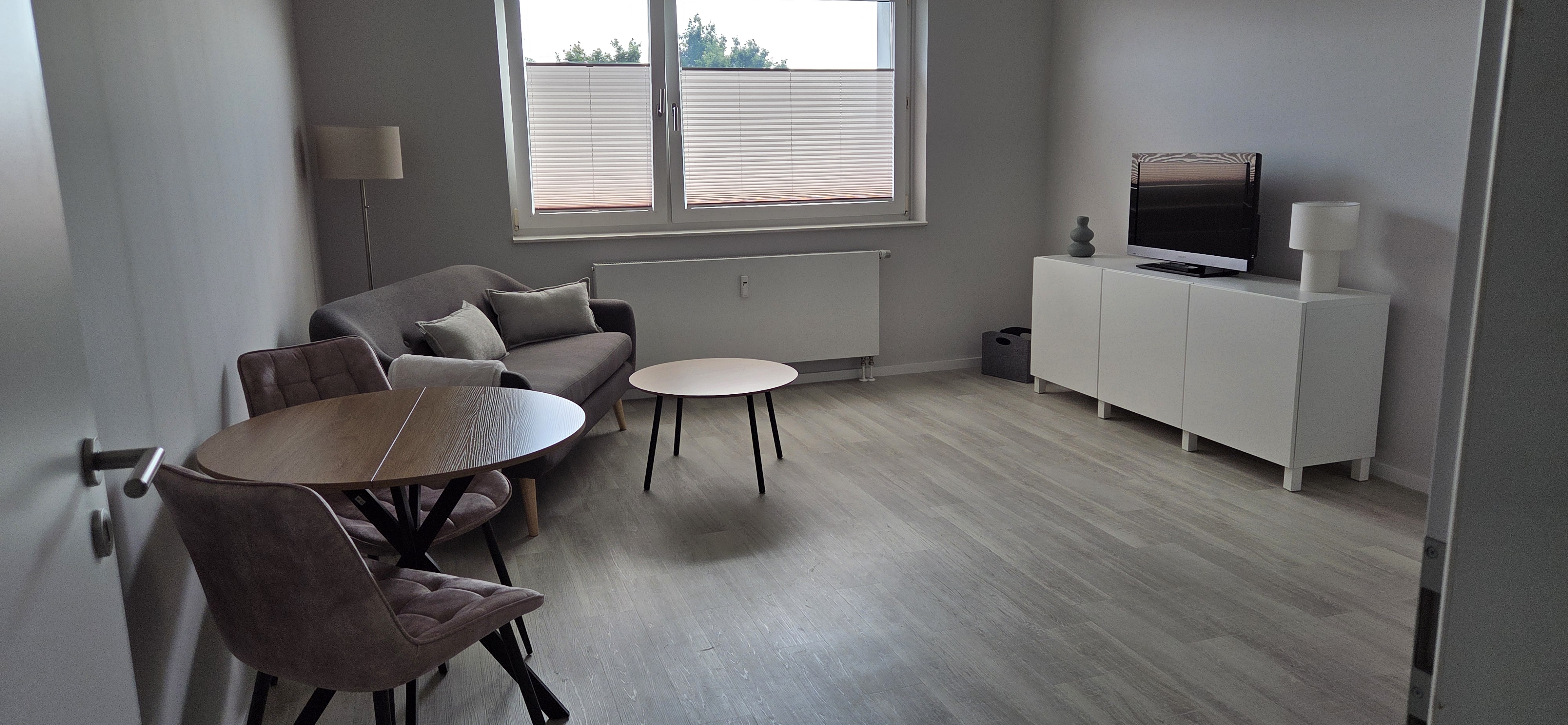 Wohnbereich mit TV-Zone und Sitzmoeglichkeit im Business-Apartment Wedel