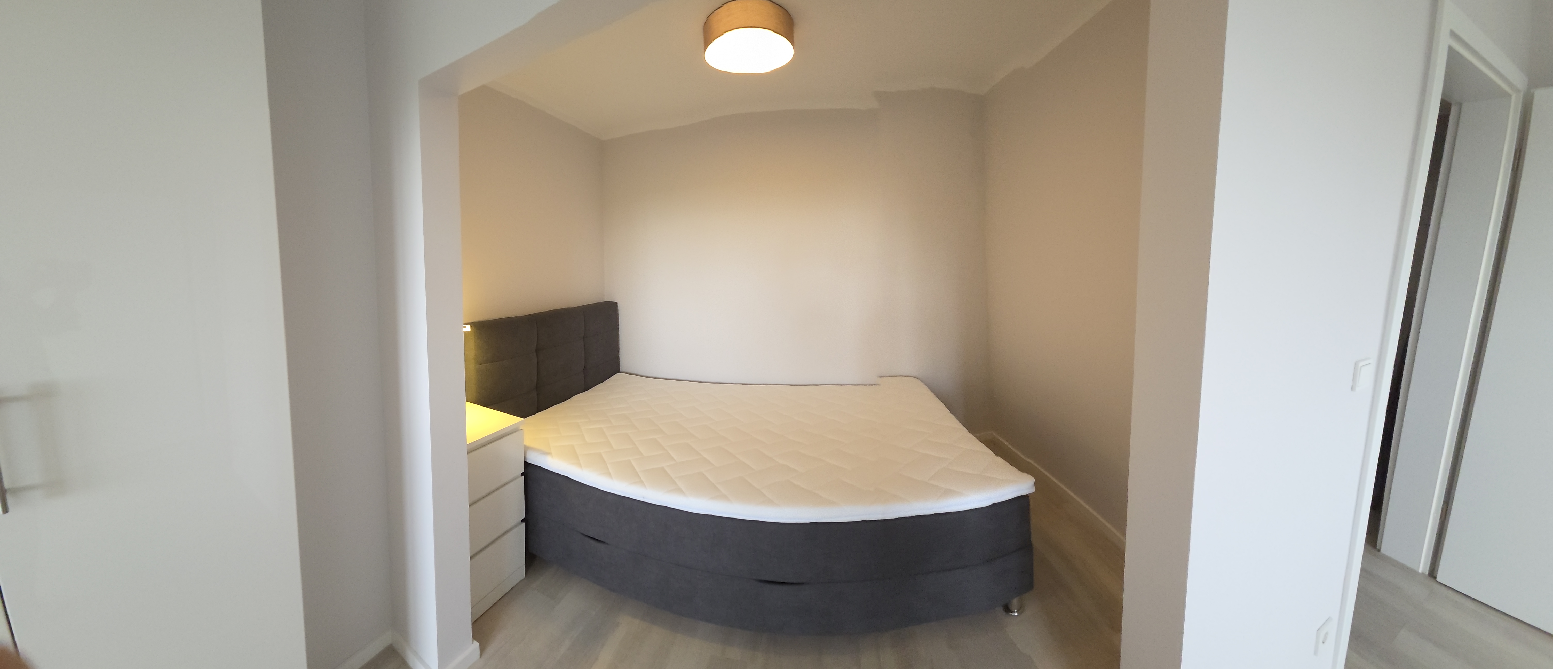 Schlafnische im Business-Studio Wedel mit Boxspringbett und Nachttisch
